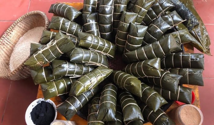 Bánh chưng Tày có màu đen và không gói vuông mà lưng bánh hơi gù